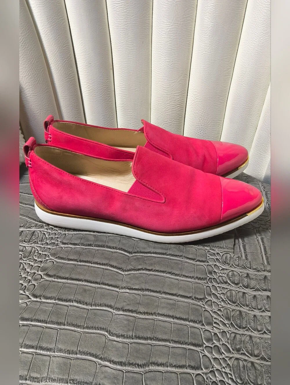Hot pink Cole Haan Grand Ambition slip-on loafers with glossy patent cap toes.